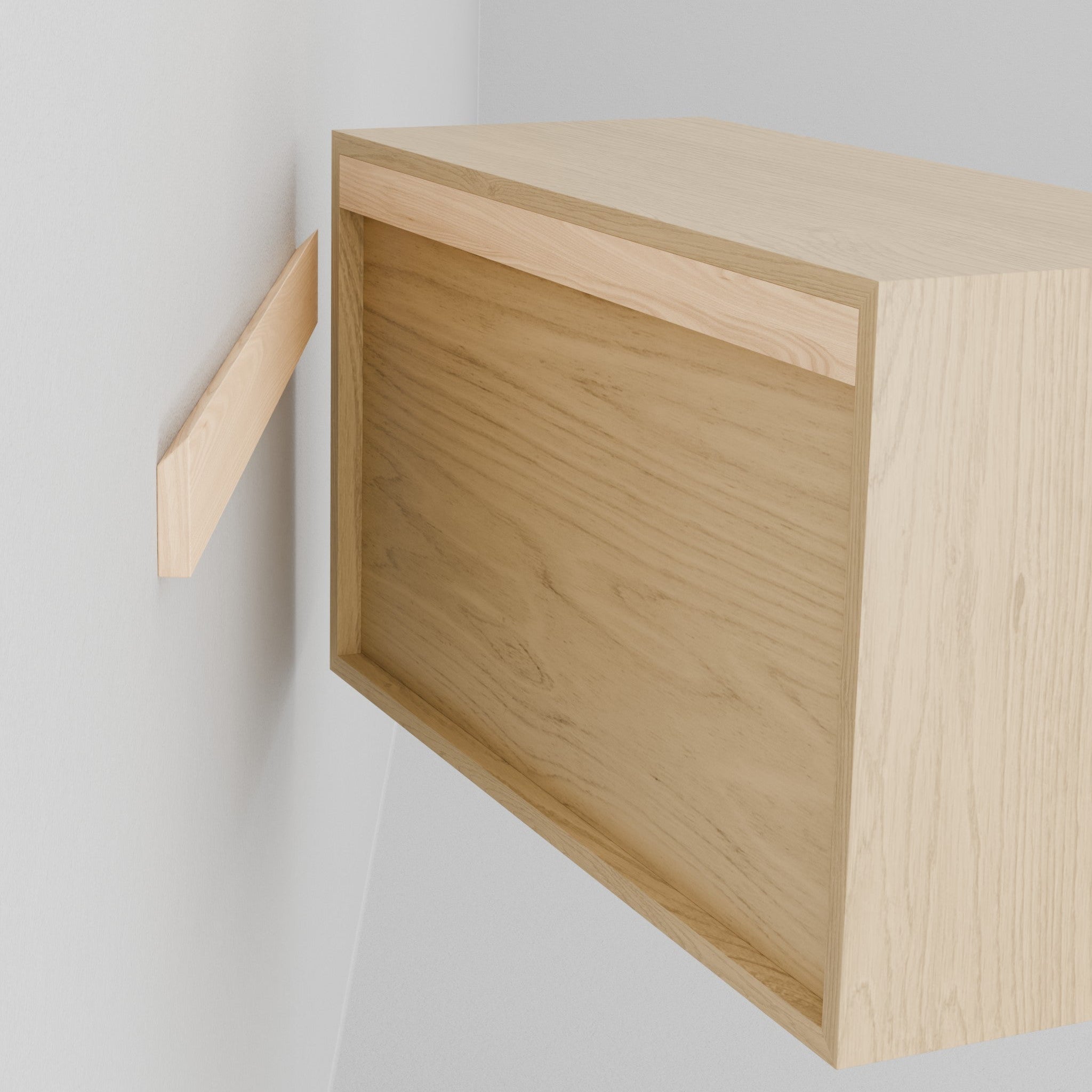 A person holds the Krovel Hardwood Floating Dresser, aligning its recessed back with a wall-mounted bracket to hang it securely using the included French cleat system.