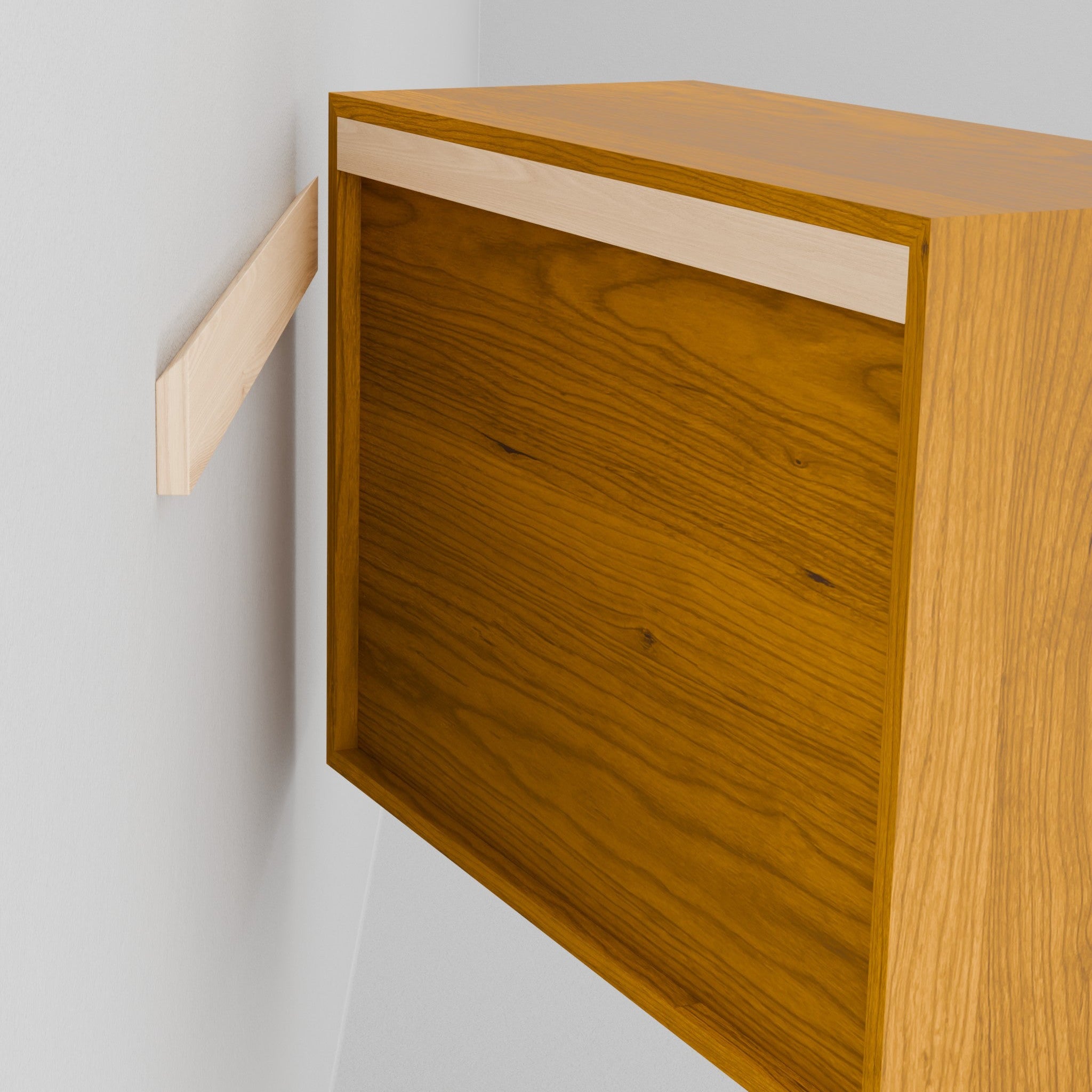 A person holds the Krovel Hardwood Floating Dresser, aligning its recessed back with a wall-mounted bracket to hang it securely using the included French cleat system.