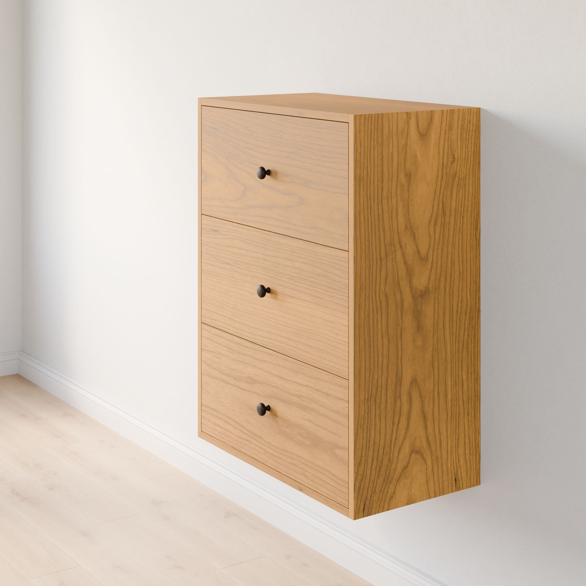 The Maine Made Closet Drawers by Krovel Furniture Co. is a wall-mounted light wood chest with three drawers and black knobs, crafted from premium cabinet plywood, perfect for organizing closets above light hardwood floors.