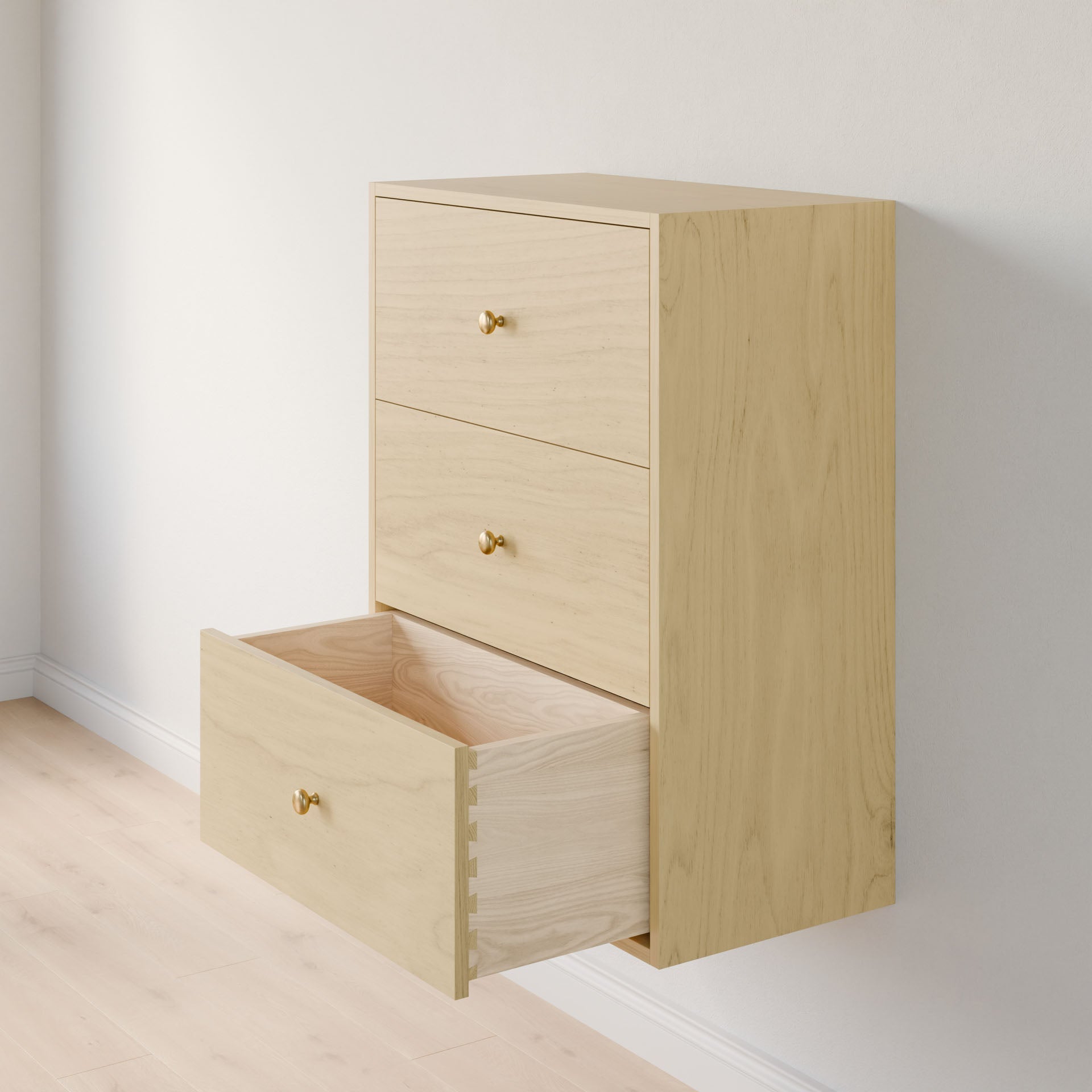 The Maine Made Closet Drawers by Krovel Furniture Co. features three light wood, wall-mounted drawers crafted from premium cabinet plywood with gold knobs, shown open for closet organization against a white wall and light wood floor.