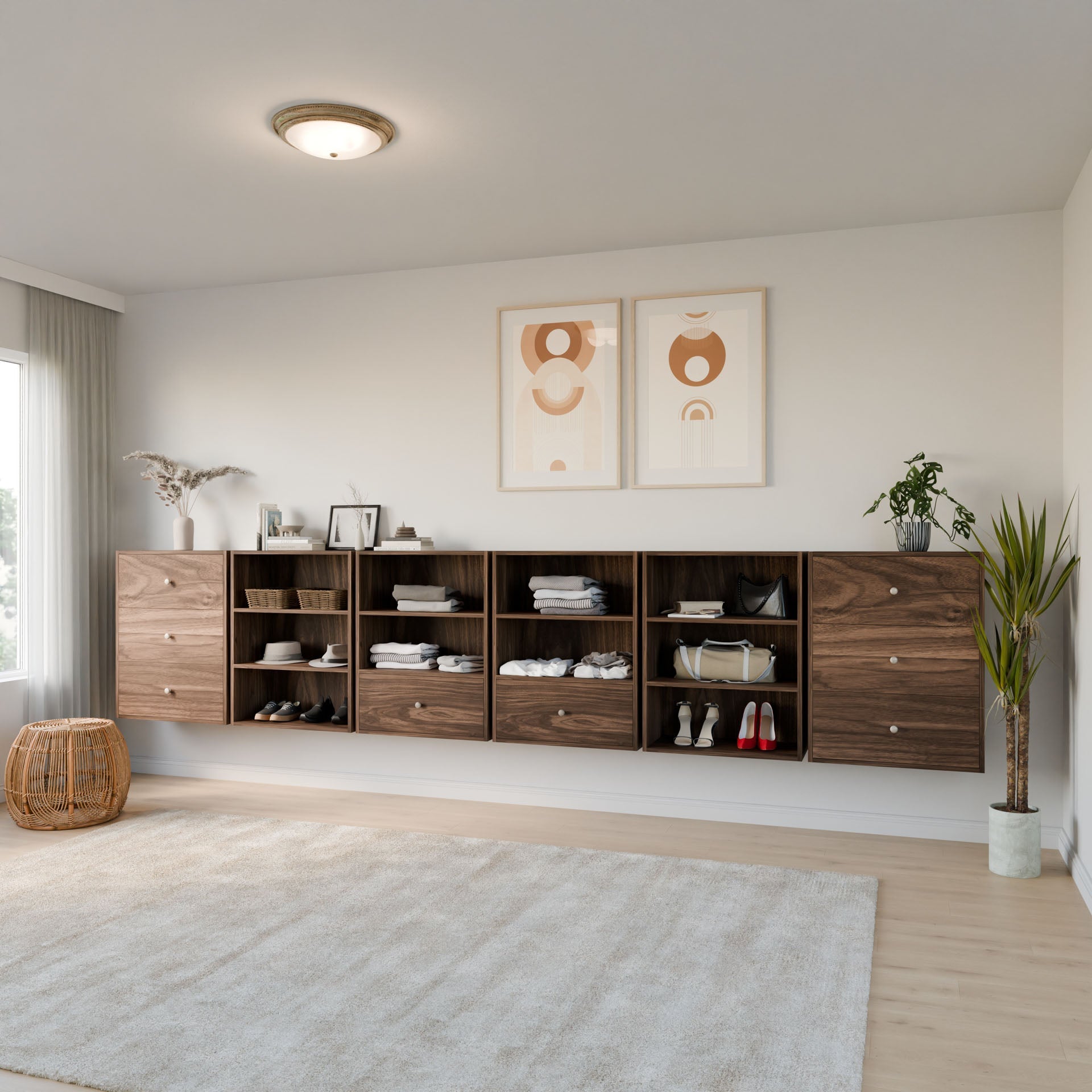 A bright, minimal living space features Krovel Furniture Co.’s Maine Made Closet Drawers crafted from premium cabinet plywood, neatly storing clothes and shoes. Abstract art prints, plants, a rug, and a wicker basket complete the inviting look.