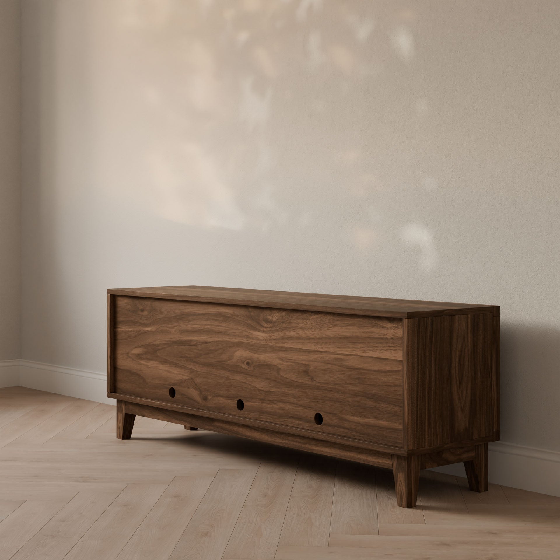 The Maine Made Double Door, Open Shelf Media Cabinet by Krovel Furniture Co. features a formaldehyde-free wood build and natural finish, highlighted against a light wall and herringbone floor for a calm, minimalist media storage solution.