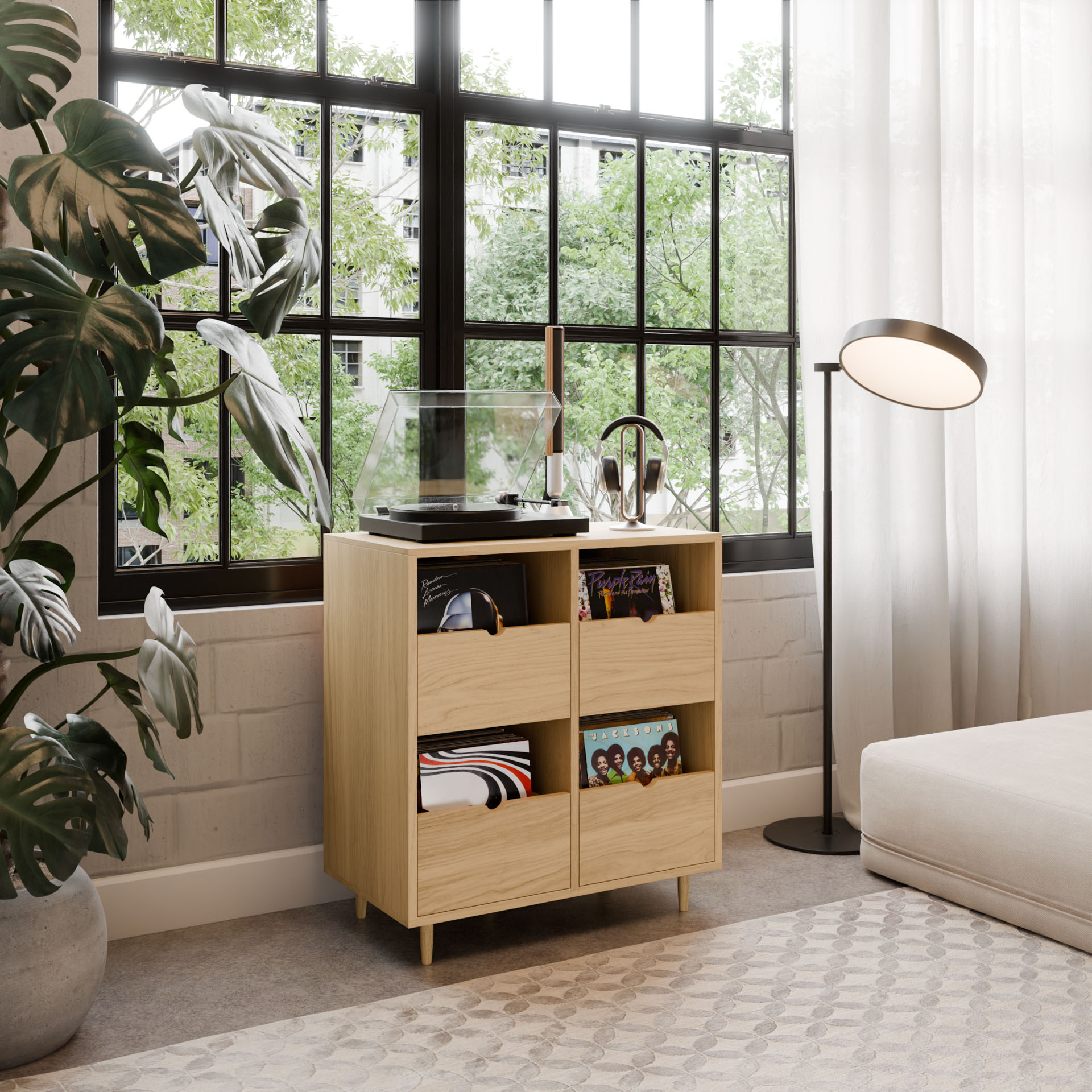 A modern living room features the Krovel Hardwood Four Drawer Record Credenza, neatly storing a turntable, records, and headphones by a large window. A leafy plant, floor lamp, and beige sofa complete the cozy, sunlit space.