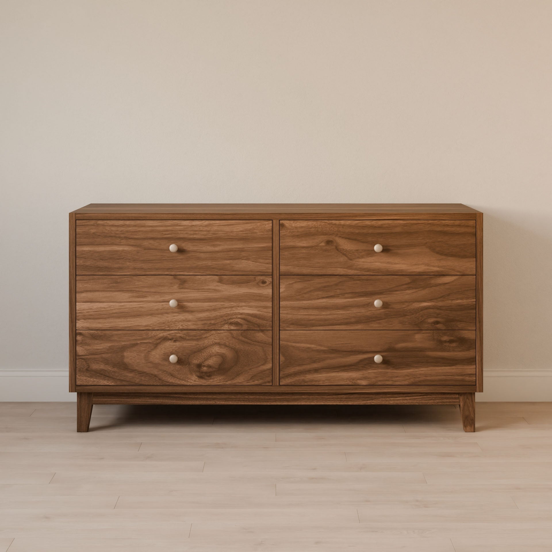 The Maine Made Six Drawer Dresser by Krovel Furniture Co. features solid wood veneer, a modern design with visible grain, six drawers with round white knobs, and stands on a light wood floor against a plain beige wall.