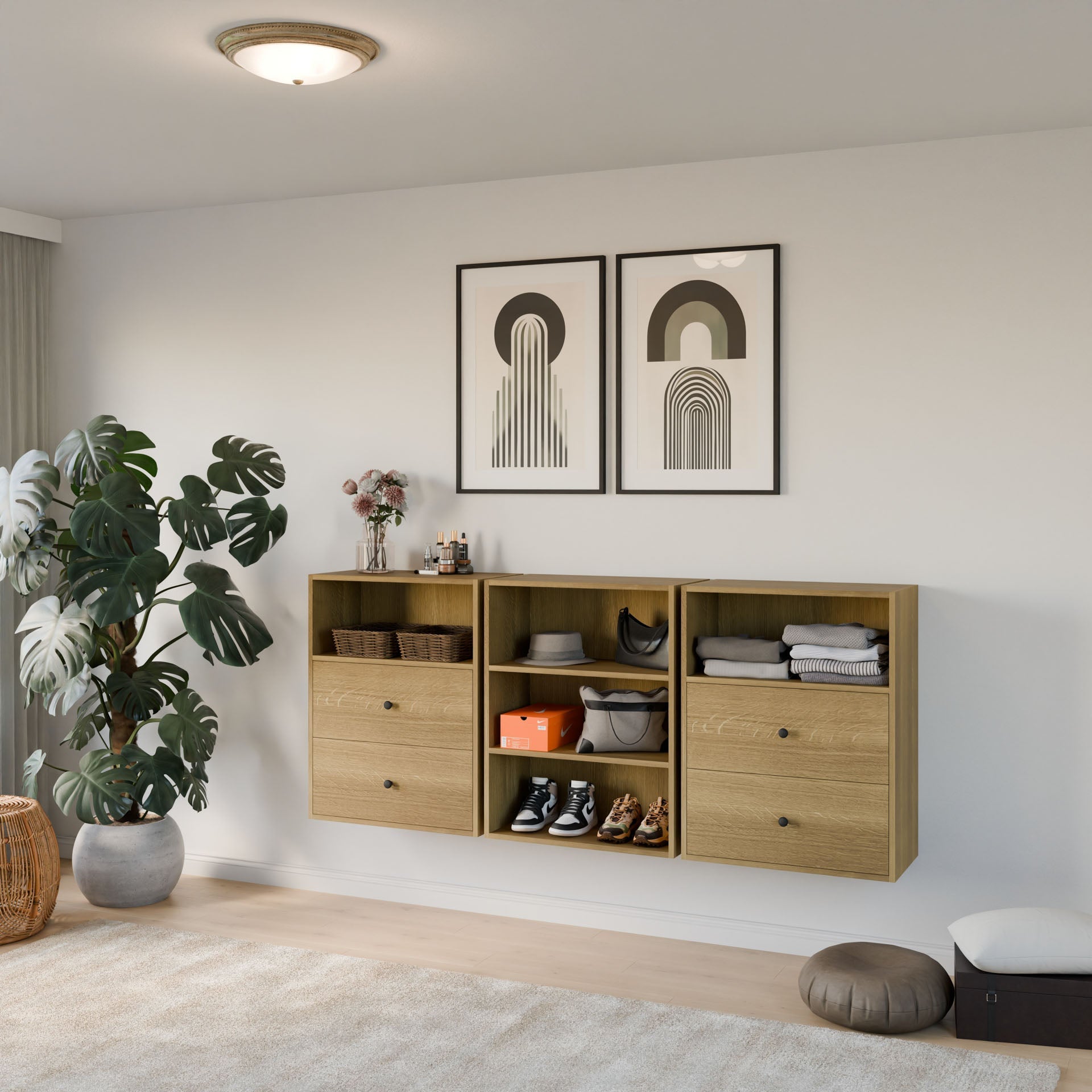 A modern, minimal living space with wall-mounted wooden storage, houseplants, two framed abstract art pieces on a white wall, shoes and accessories, and light wood flooring.