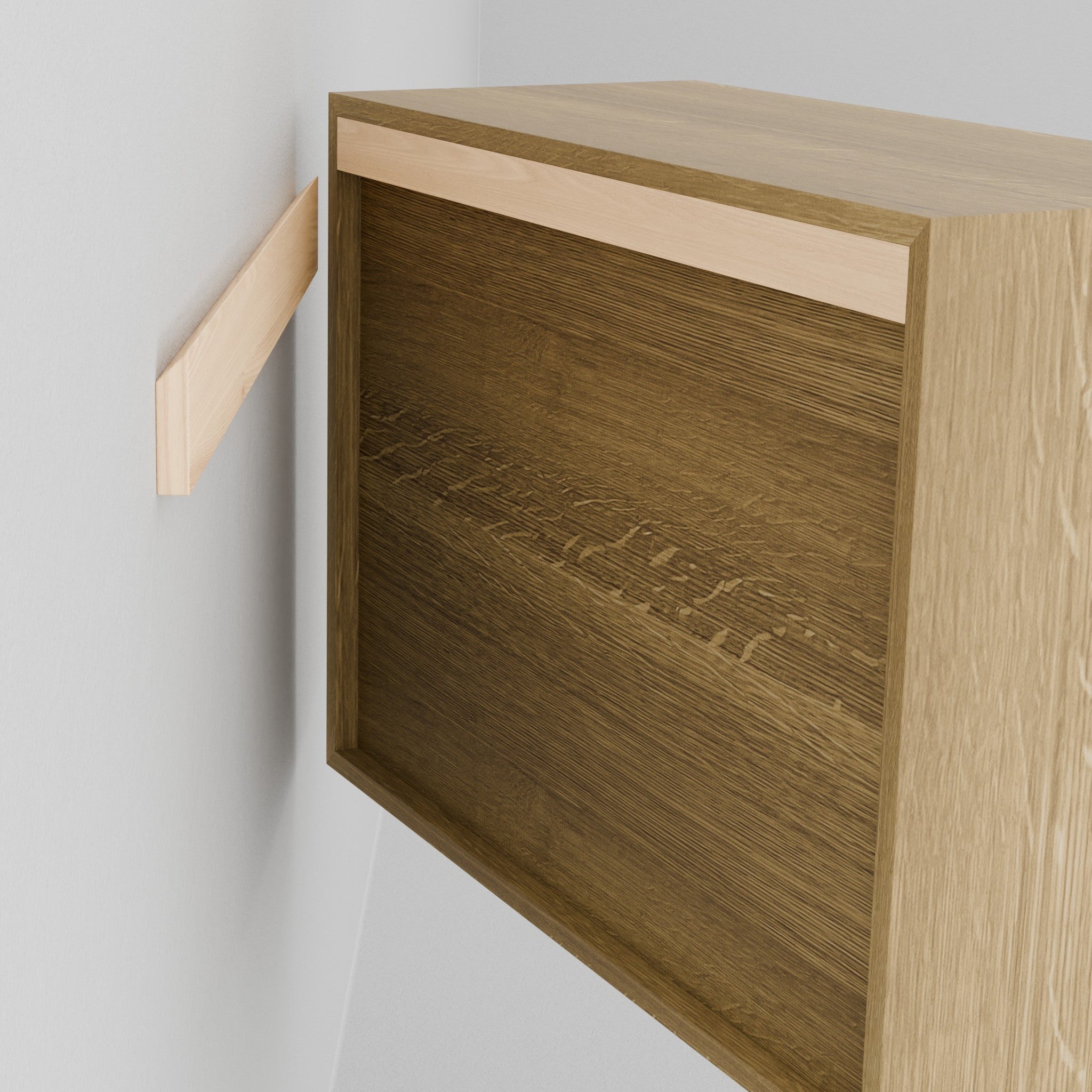 A person in a black shirt aligns the Krovel Hardwood Floating Dresser, featuring a recessed back, with its matching wall mount strip. Both pieces are made of light-colored hardwood. Part of the person’s arm is visible.