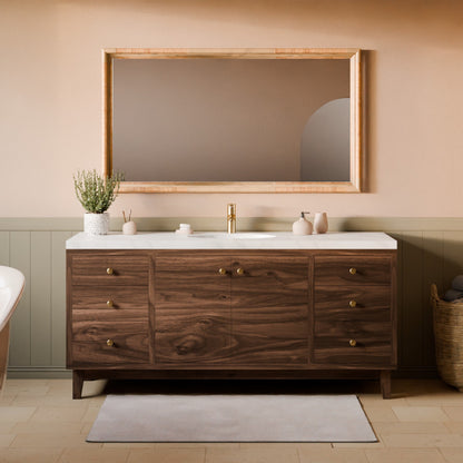 A modern bathroom vanity with a dark wood cabinet, white marble countertop, and a large rectangular mirror with a light wood frame, set against a beige wall with green wainscoting.