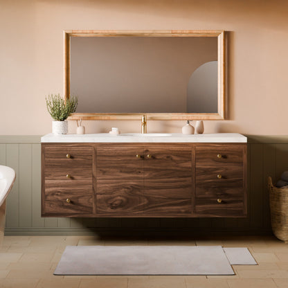 A floating bathroom vanity with a dark wood cabinet, white countertop, and a large rectangular mirror with a light wood frame, set against a warm beige wall with green wainscoting.