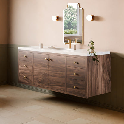 A floating bathroom vanity with a dark wood cabinet, white countertop, and gold faucet, shown in a styled bathroom setting with a mirror, wall sconces, and tiled floor.