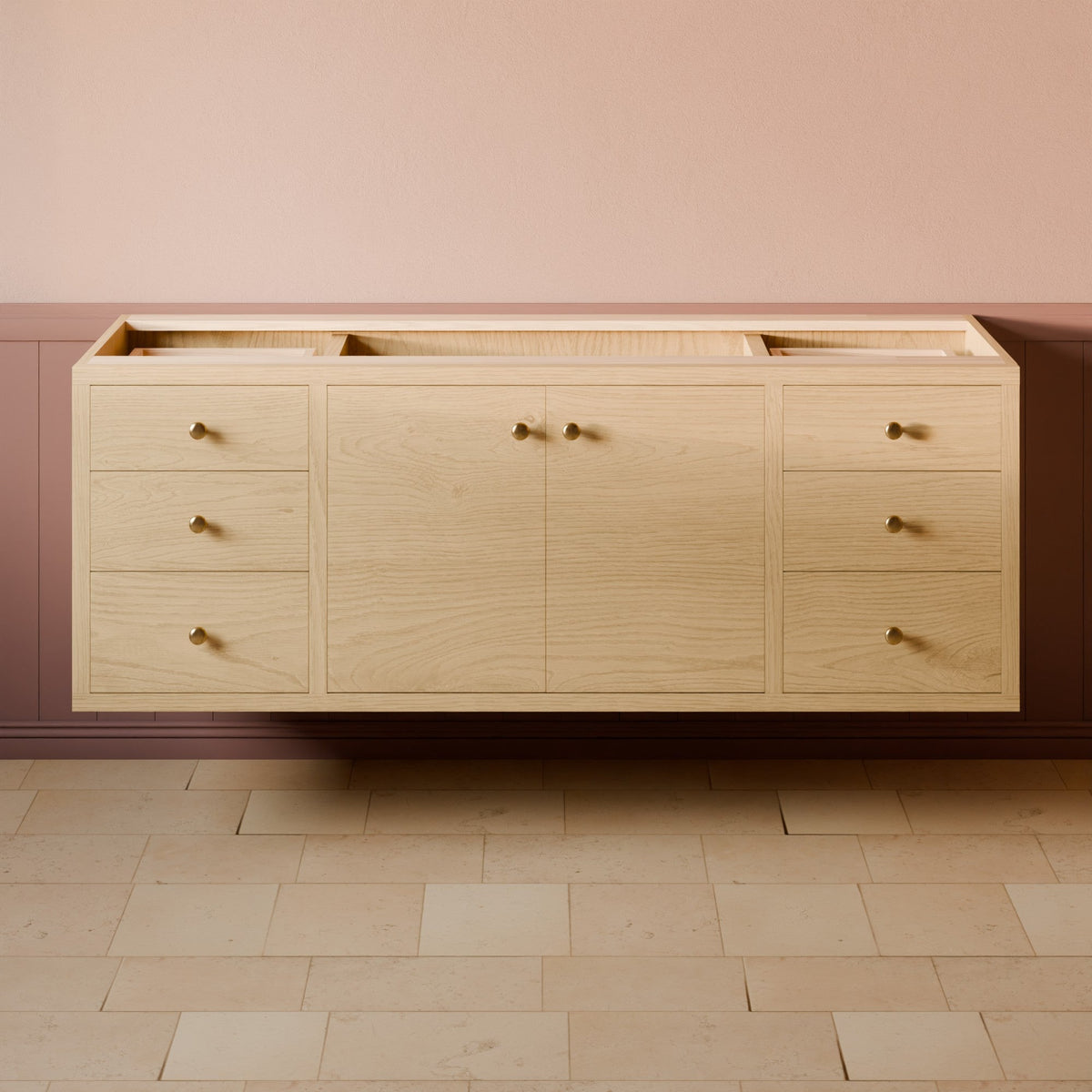 A light natural wood bathroom vanity cabinet with multiple drawers and two central doors, mounted against a pink wall above a beige stone floor.