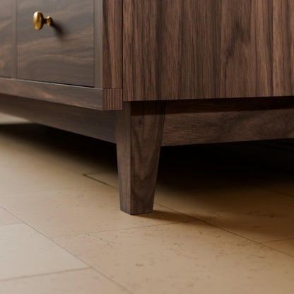 Close-up of a dark brown wood cabinet or sideboard with a brass drawer pull, shown on a light beige tiled floor.