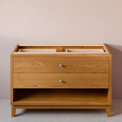 A mid-century modern wooden chest of drawers with two drawers and an open lower shelf, shown against a neutral beige wall and light gray floor.