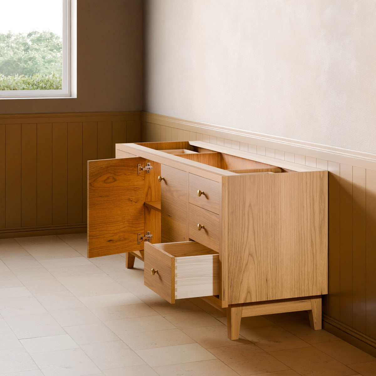 A light natural wood sideboard or credenza with brass handles, shown in a room setting with one cabinet door open and one drawer pulled out. The room features a beige wall, wood paneling, and light-colored tile flooring.