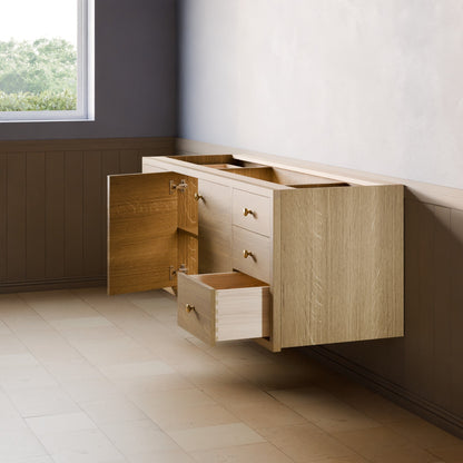 A floating wooden vanity cabinet with a light oak finish, featuring an open side cabinet door, two closed drawers, and one open drawer pulled out, set against a modern room with a tiled floor and paneled wall.