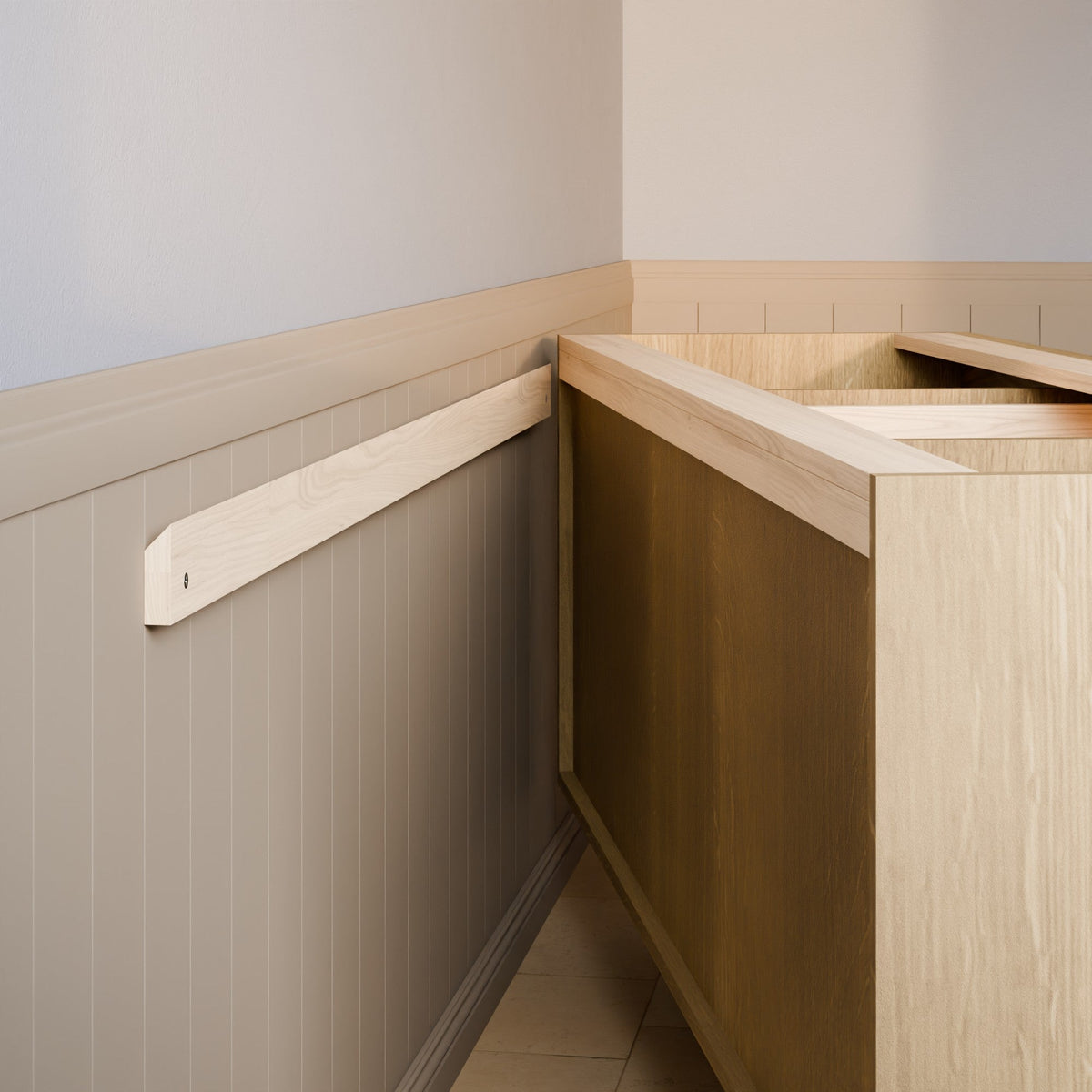 A light natural wood wall-mounted support rail installed on a beige paneled wall next to a wooden cabinet or counter in an indoor room setting.