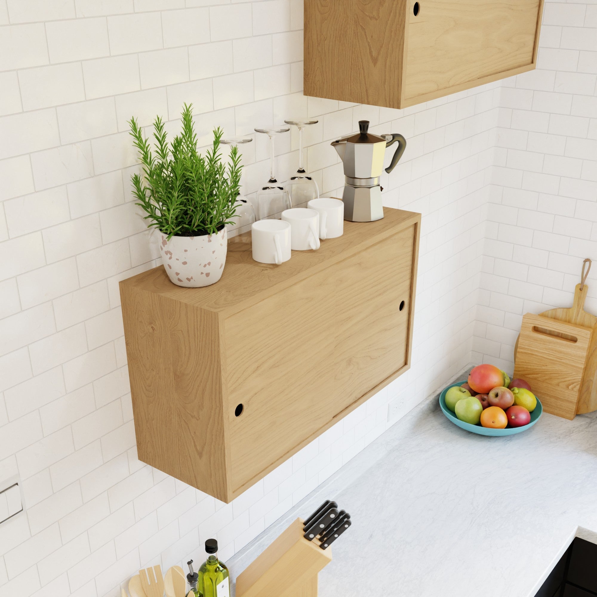 The Krovel Hardwood Cupboard Shelf is wall-mounted and displays a potted plant, four mugs, upside-down wine glasses, and a moka pot. Beneath it, a white countertop holds a fruit bowl, cutting boards, and utensils by white tiles.