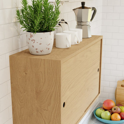 The Krovel Hardwood Cupboard Shelf is topped with a potted rosemary, three white mugs, and a moka pot. A bowl of apples and fruit sits in front, all set against a white subway tile backsplash.