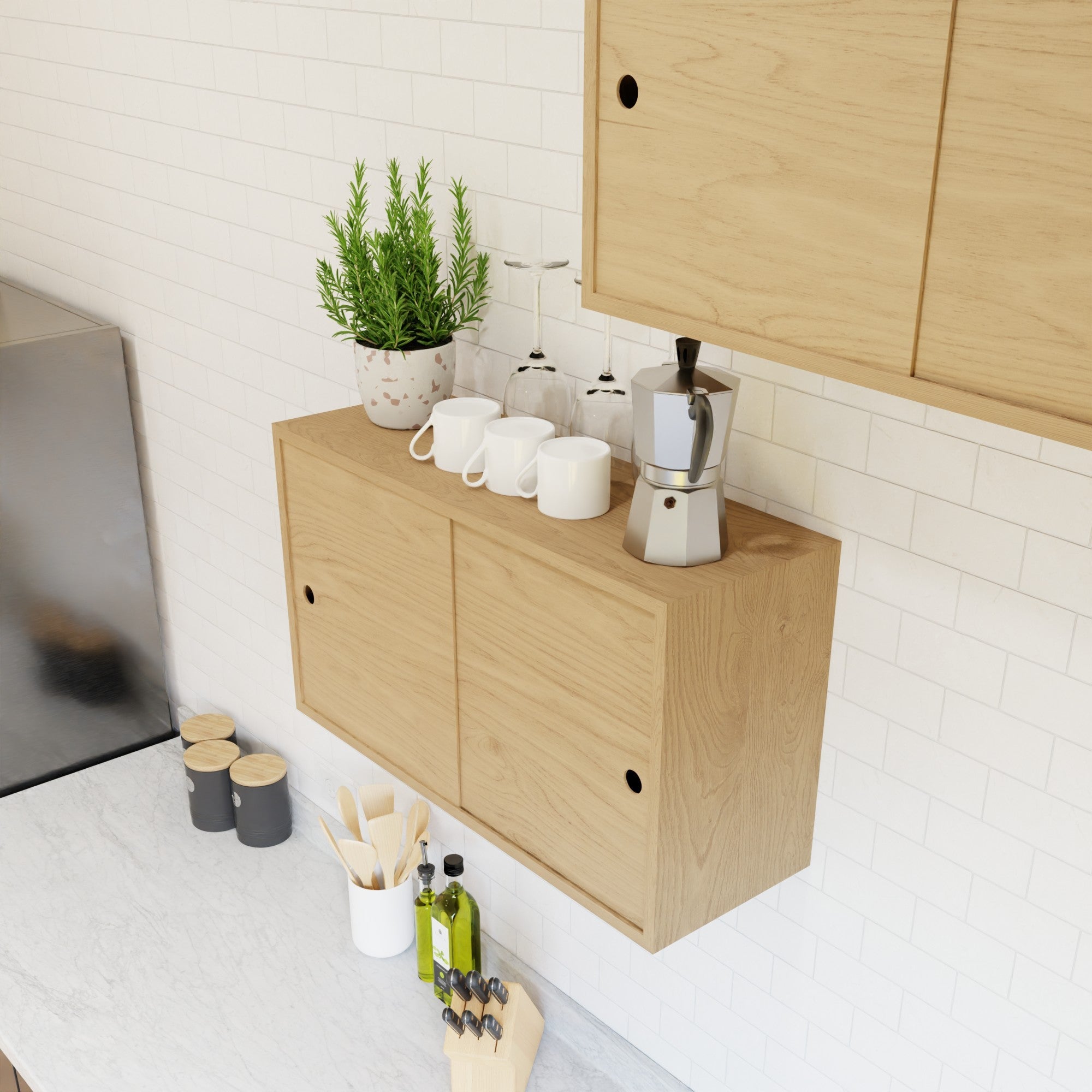 The Krovel Hardwood Cupboard Shelf holds a potted herb, white cups, wine glasses, and a stovetop espresso maker. Below, a marble countertop keeps utensils, condiments, and a knife block within easy reach.