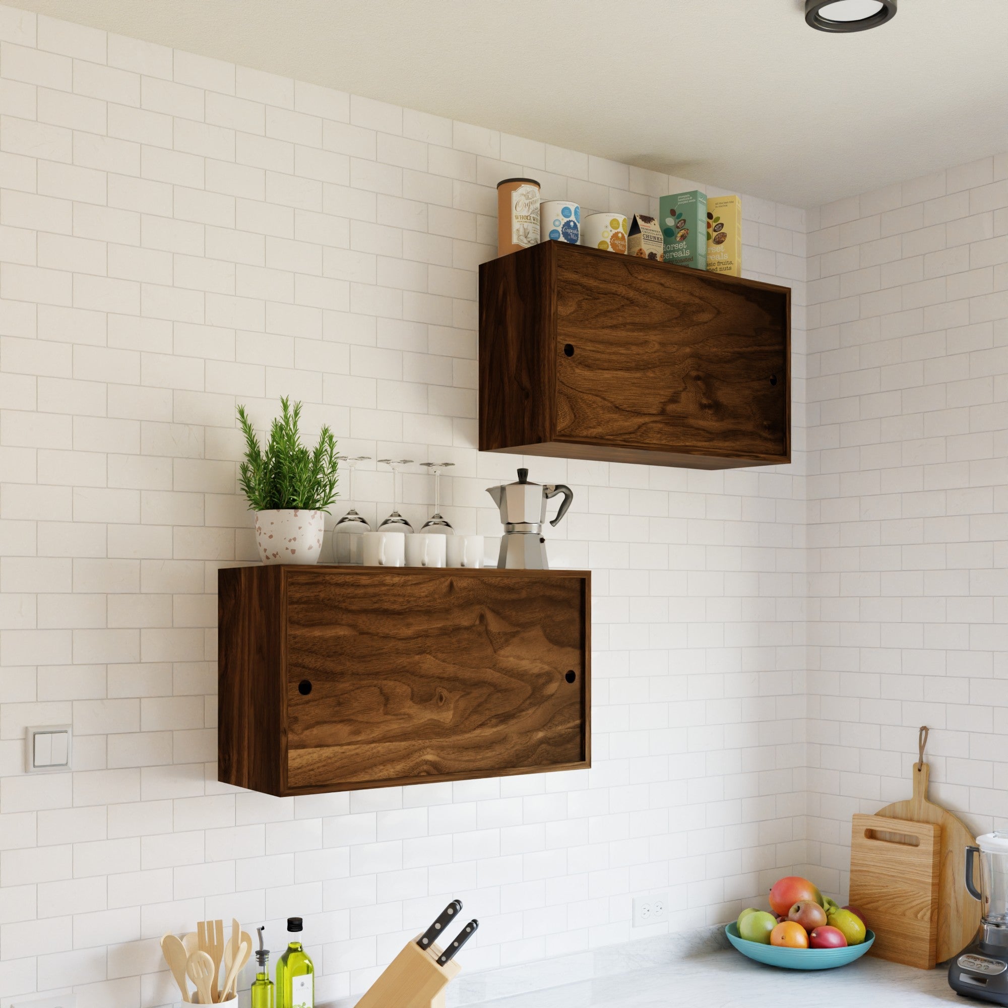 Modern kitchen with white subway tile walls, two Krovel Hardwood Cupboard Shelves, utensils, a potted herb, bottles, dishes, and groceries on the counter, plus a cutting board topped with fruit and vegetables.