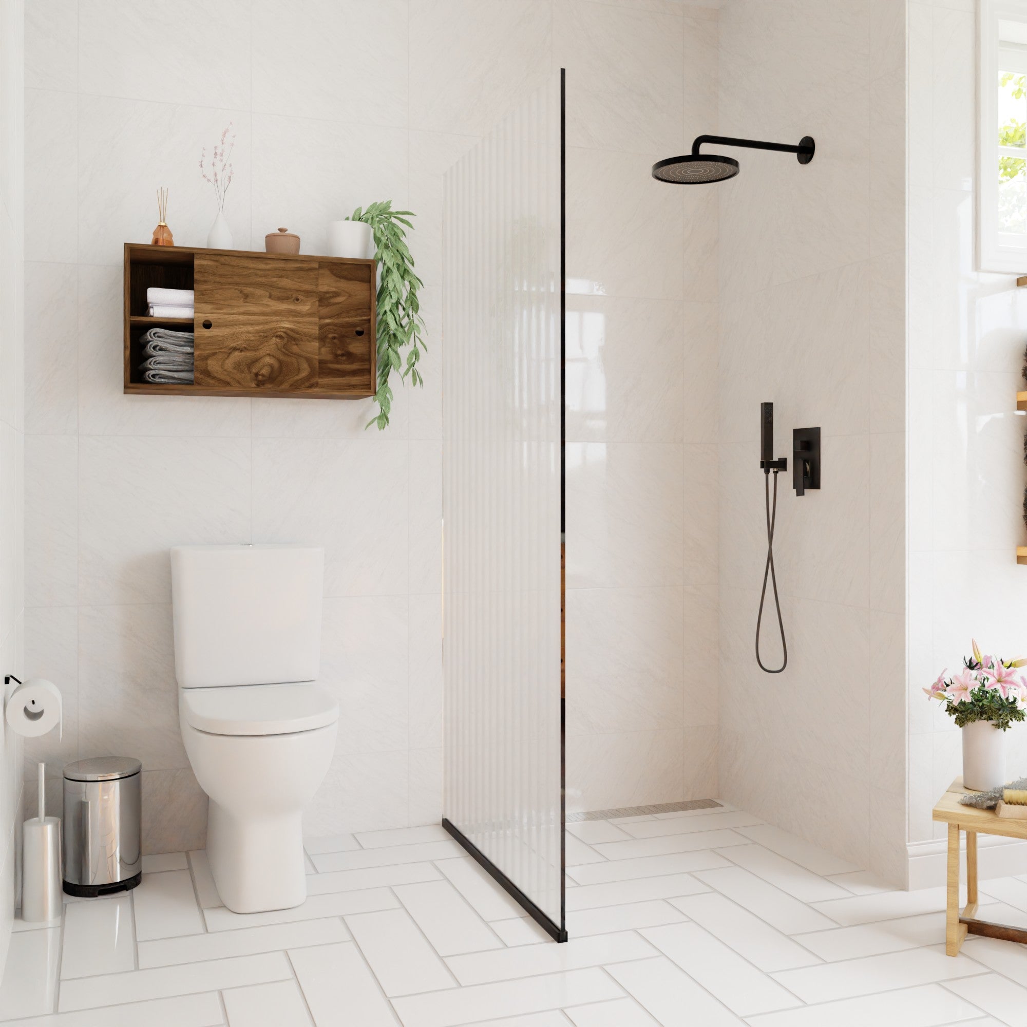 Modern bathroom with walk-in shower, glass divider, wall-mounted showerhead, white toilet, floating storage cabinet, Krovel Hardwood Cupboard Shelf with towels and plants, trash bin, toilet paper, and flowers on a stool. White tile walls and floor.
