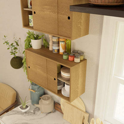 The Krovel Hardwood Cupboard Shelf is mounted on a beige wall above a marble countertop with a blue kettle, cups, and white pot near a bright window, displaying jars, plates, condiments, and plants.
