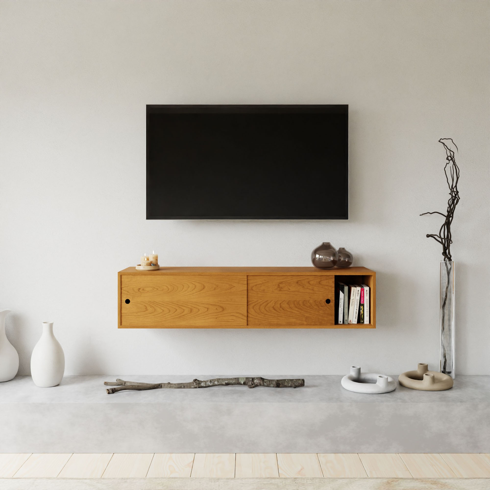 A modern minimalist living room features a wall-mounted TV above a sleek wooden cabinet from Krovel Furniture Co. Vases, decorative branches, and a few small objects rest on the light hardwood floor. The space is characterized by neutral tones and simple design.