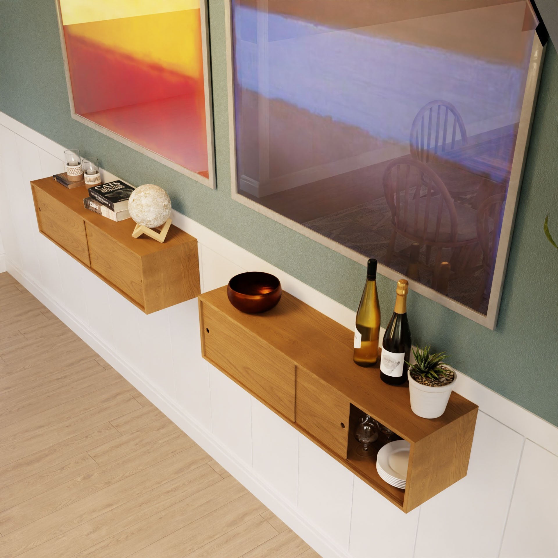 The Krovel Floating Storage Cabinet in Cherry holds wine bottles, bowls, books, a plant, and décor below two colorful framed artworks on a green and white wall with light wood flooring.
