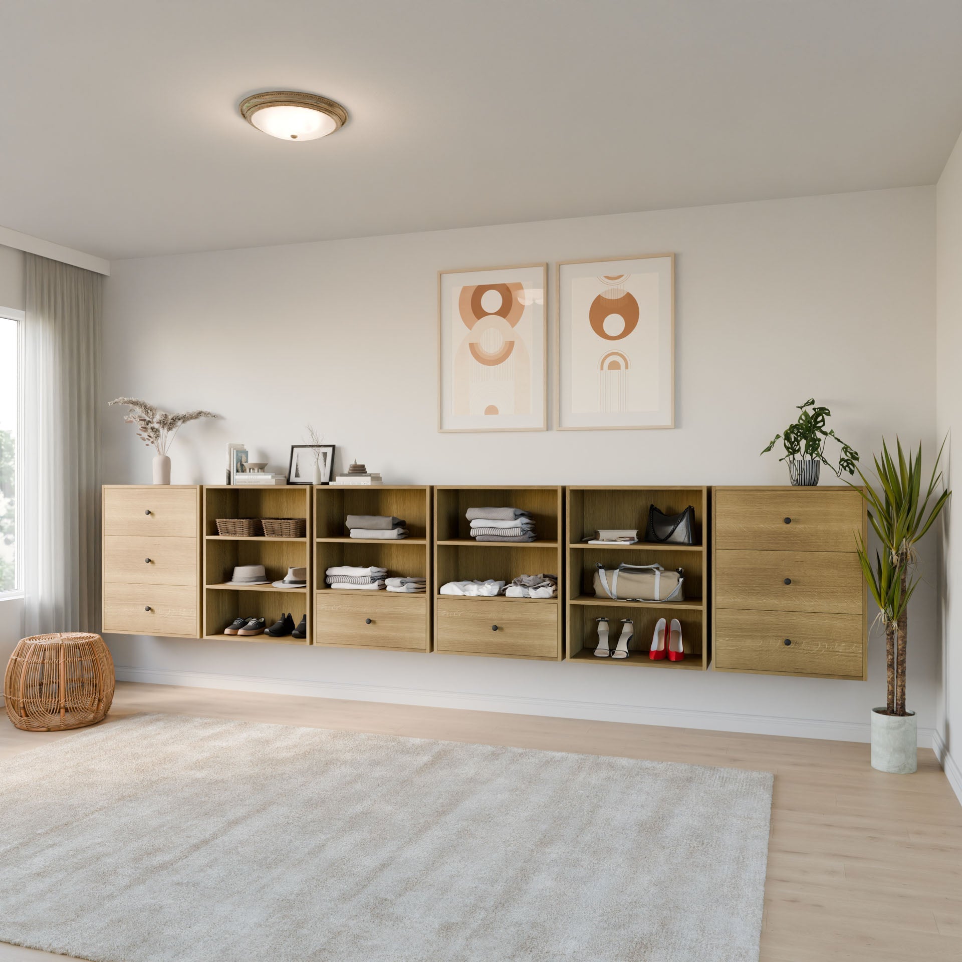A modern bedroom features Krovel Furniture Co.’s Maine Made Closet Drawers, wall-mounted and modular for organized clothes, shoes, and decor. Two abstract prints hang above; a rug, plants, and soft natural light complete the cozy space.