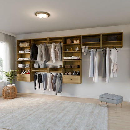 A modern, organized closet with wooden shelves and a Maine Made Closet Hanger by Krovel Furniture Co. displays clothes, shoes, hats, and bags. A small ottoman, round wicker table with plant, and rug complete the clean, bright room.