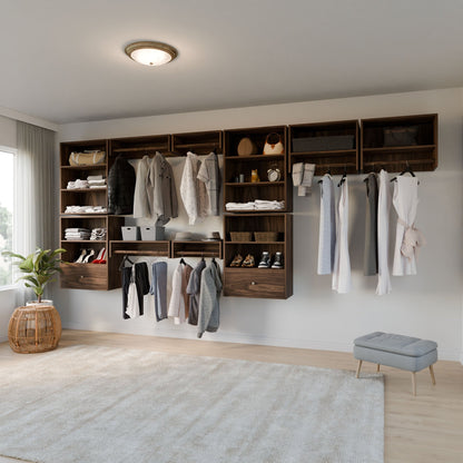 A modern closet displays clothes, bags, shoes, and boxes on Maine Made Closet Hanger with Shelf by Krovel Furniture Co., featuring premium cabinet plywood. The bright room also has a potted plant, small stool, and a large rug.