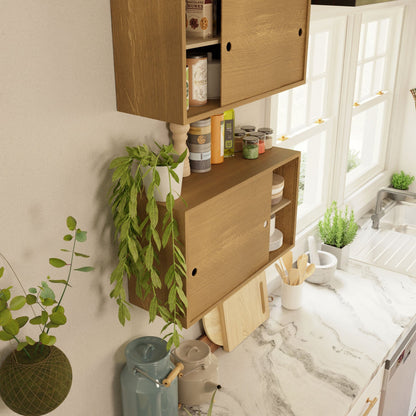 The kitchen features a Krovel Cupboard with Shelf in White Oak, alongside potted plants and various jars and cans. The white marble countertop is adorned with a few utensils, cutting boards, and blue containers. Sunlight streams through a window above a stainless steel sink, enhancing the handmade charm of this space.