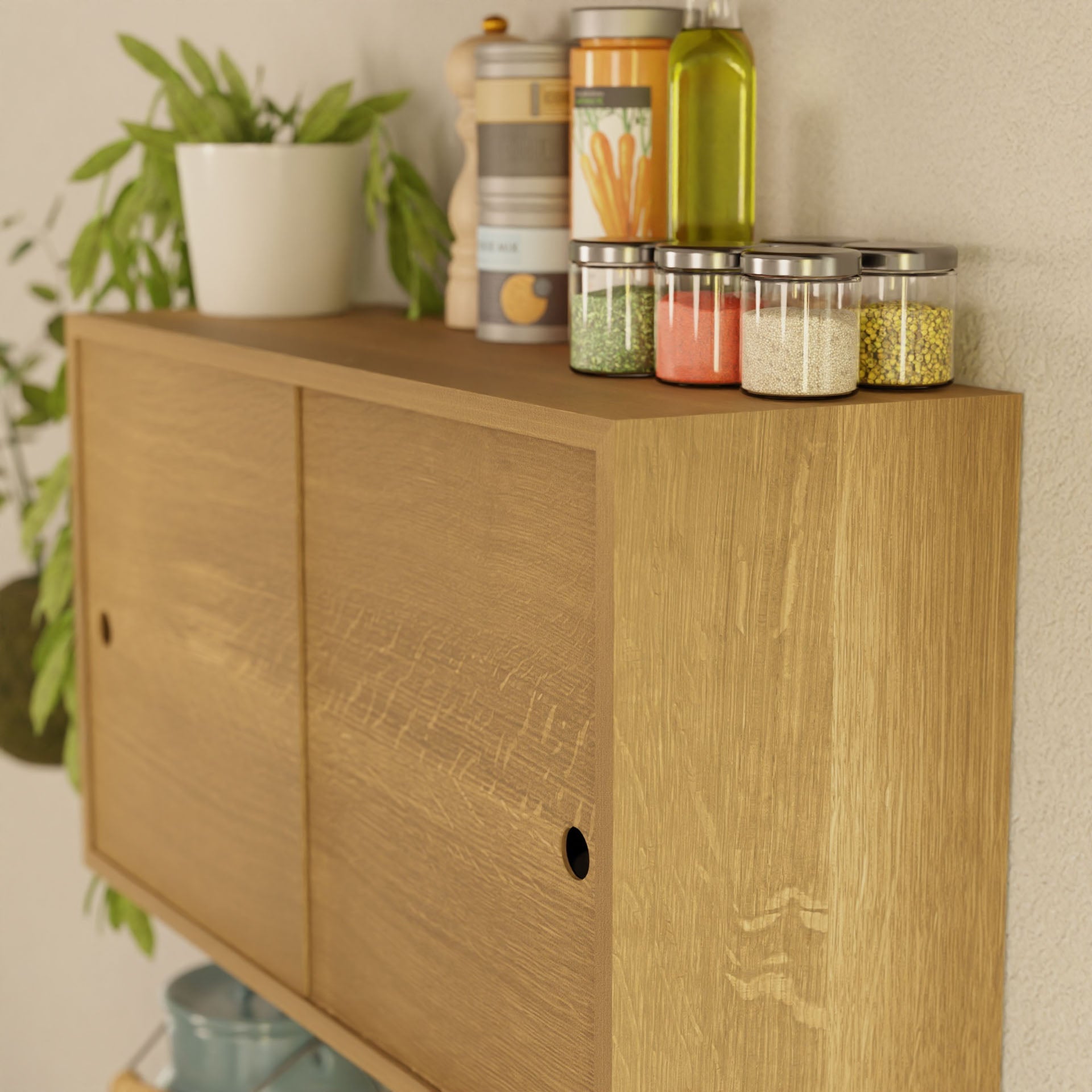 The Krovel Cupboard with Shelf in White Oak features sliding doors elegantly housing spice jars, a pepper grinder, and an oil bottle. A potted plant adds greenery on the left side. Handmade and mounted against a light wall, it combines functionality with style.