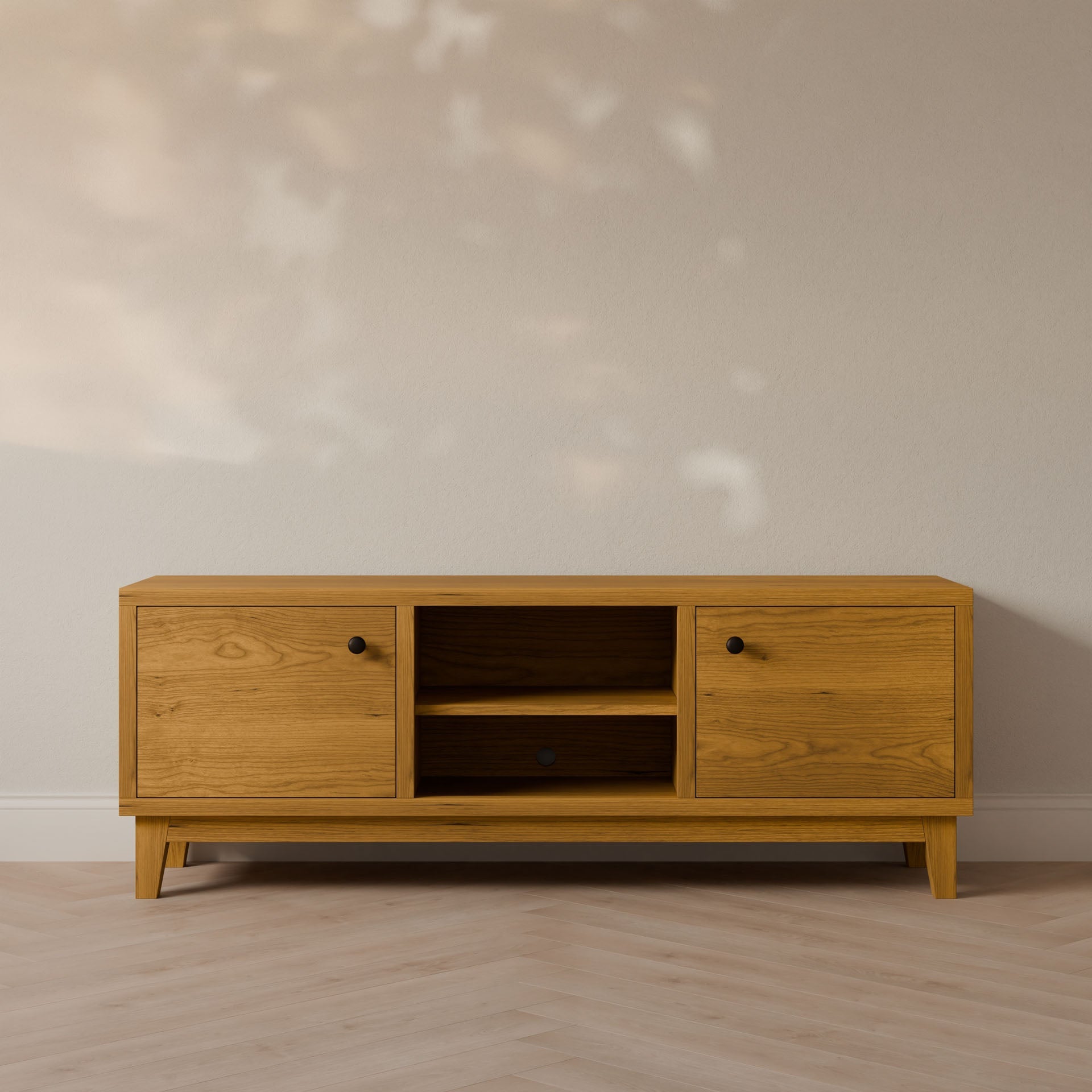 The Double Door, Open Shelf Media Cabinet in Cherry by Krovel Furniture Co. is a minimalist wooden TV stand with formaldehyde-free hardwood veneer, featuring two closed cabinets and central open shelves. Handmade in Portland, it sits on a light wood finish floor against a neutral wall in soft light.