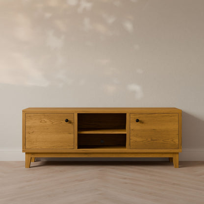 The Double Door, Open Shelf Media Cabinet in Cherry by Krovel Furniture Co. is a minimalist wooden TV stand with formaldehyde-free hardwood veneer, featuring two closed cabinets and central open shelves. Handmade in Portland, it sits on a light wood finish floor against a neutral wall in soft light.
