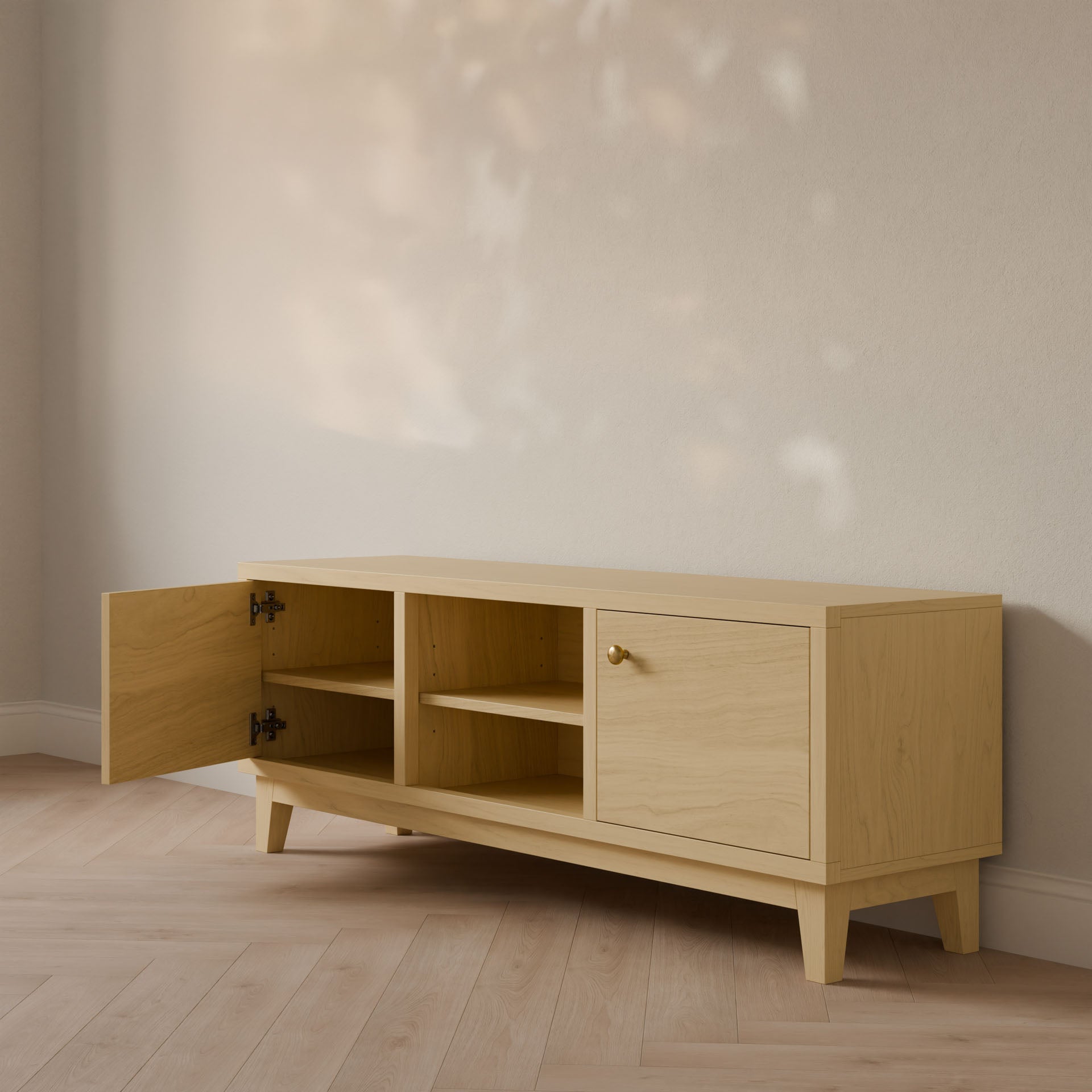 The Krovel Furniture Co. Maple Media Cabinet features a customizable light wood finish with angled legs, hardwood veneer, and multiple compartments—one closed and one open with shelves—standing elegantly against a neutral wall, perfectly complementing the light wood flooring.
