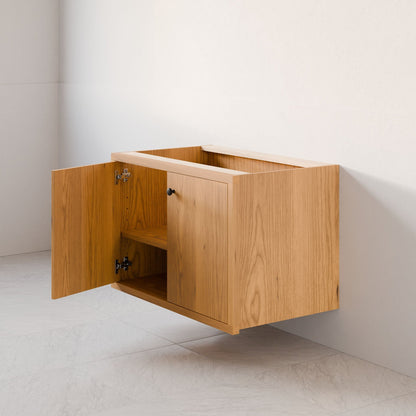 The Maine Made Double Door Vanity by Krovel Furniture Co. is a hardwood floating cabinet with open doors, showing two shelves, and is mounted on a white wall above a tiled floor.