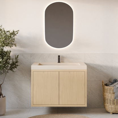 A modern bathroom with a Krovel Furniture Co. Double Door Vanity in Maple, rectangular sink, oval backlit mirror, potted plant on the left, and a wicker basket with towels on the right against light tile walls.