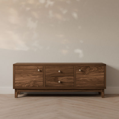 The Krovel Furniture Co. Maine Made Double Drawer, Double Door Media Cabinet stands against a light wall on a herringbone wood floor, with soft natural light casting subtle shadows on the scene.