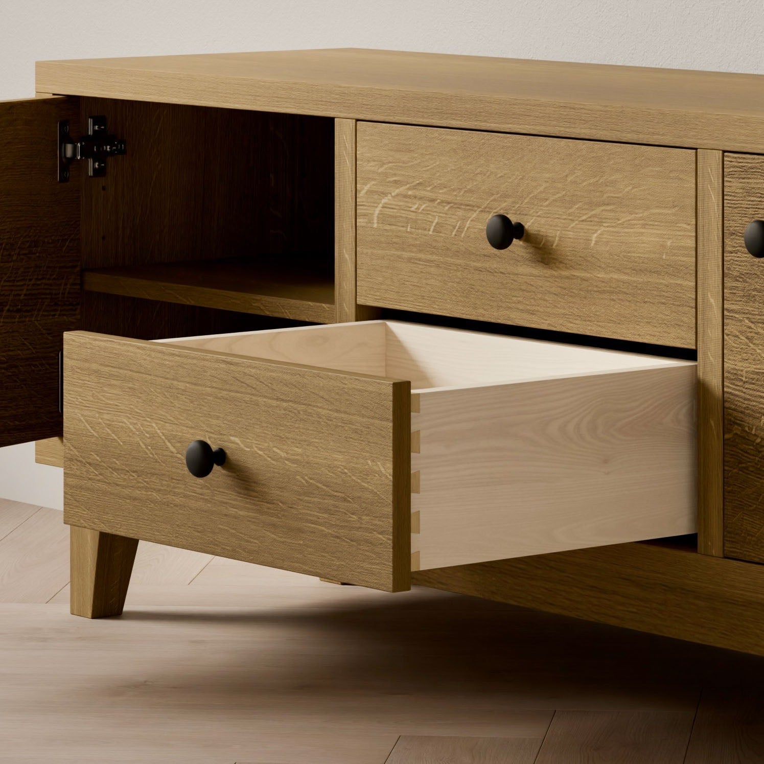 The Maine Made Double Drawer, Double Door Media Cabinet by Krovel Furniture Co. is handmade in Portland, ME, featuring two drawers and double doors—one drawer partially open to show the light wood interior and one door ajar revealing an empty shelf inside.
