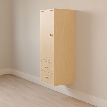 The Maine Made Double Drawer Linen Cabinet by Krovel Furniture Co. features solid hardwood in light wood, a wall-mounted design with a top door and two drawers below, each with small round knobs, shown against a light wall and floor.
