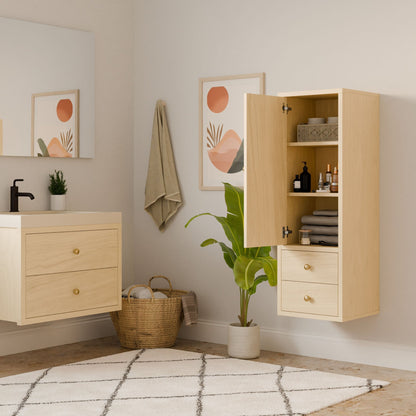 A modern bathroom showcases a Krovel Furniture Co. Double Drawer Linen Cabinet in Maple with its door open to display neatly arranged toiletries. Beneath a towel, a framed abstract art piece complements the vanitys large mirror and small plant, while a potted plant and woven basket sit on the floor for added elegance.