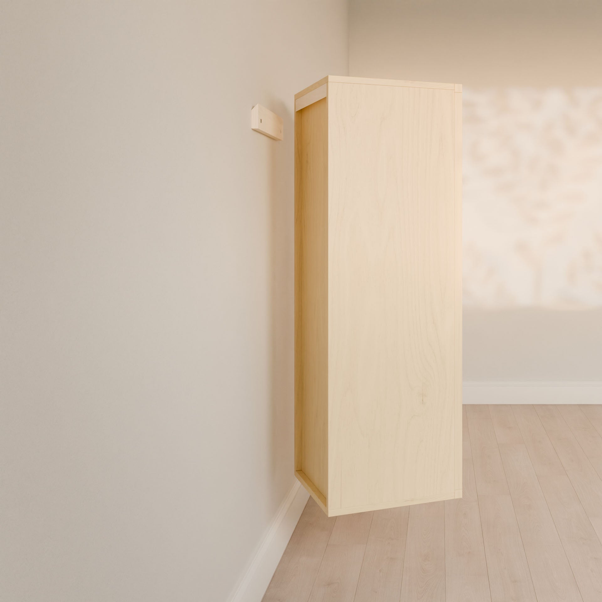 The Double Drawer Linen Cabinet in Maple by Krovel Furniture Co. is mounted sideways on a wall in a minimalistic room with pale wood flooring, where sunlight creates soft, dappled shadows, enhancing the calming atmosphere.