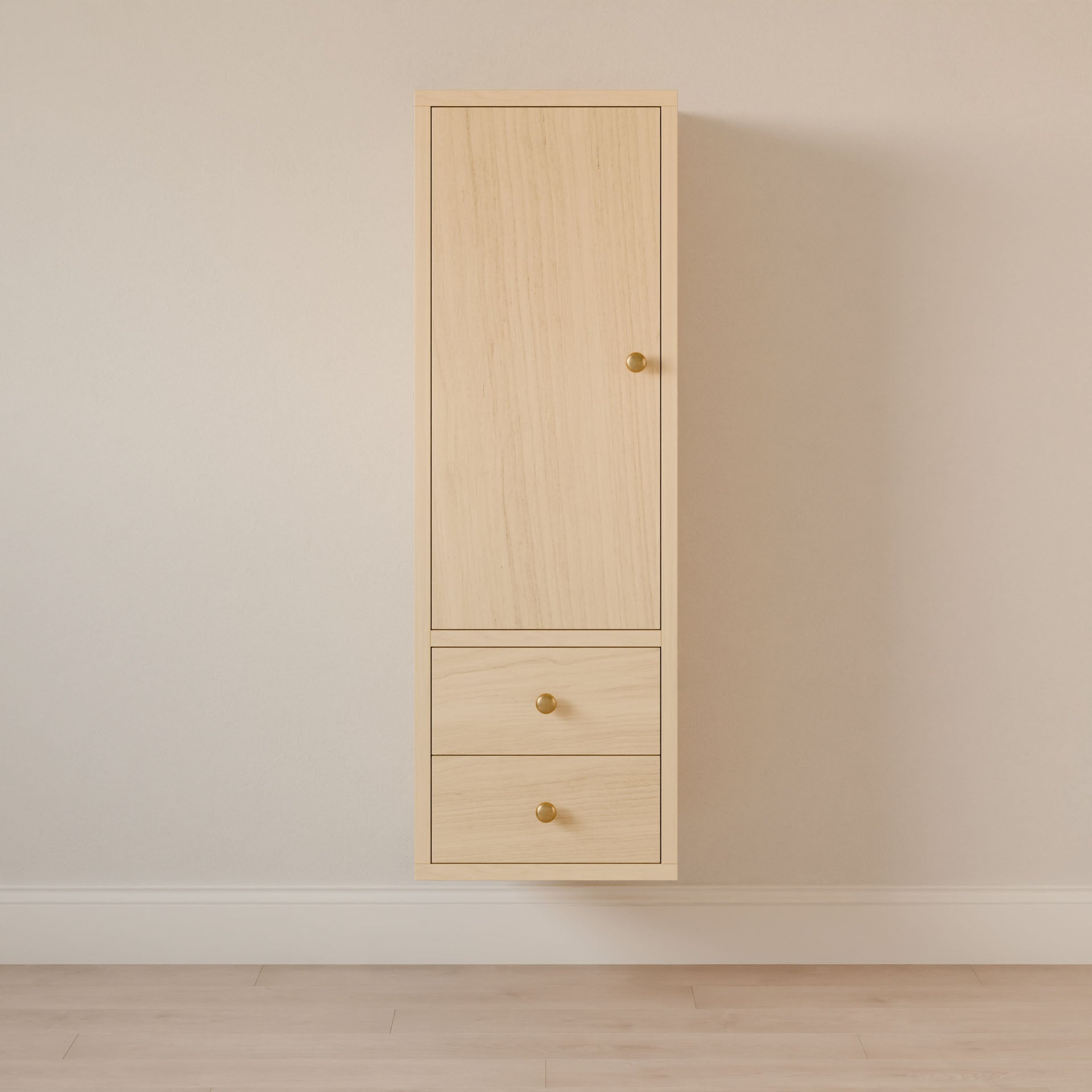 The Maine Made Double Drawer Linen Cabinet by Krovel Furniture Co. features light wood hardwood, a tall upper door, and two lower drawers with gold knobs—perfect as a bathroom vanity cabinet against off-white walls and a light wood floor.