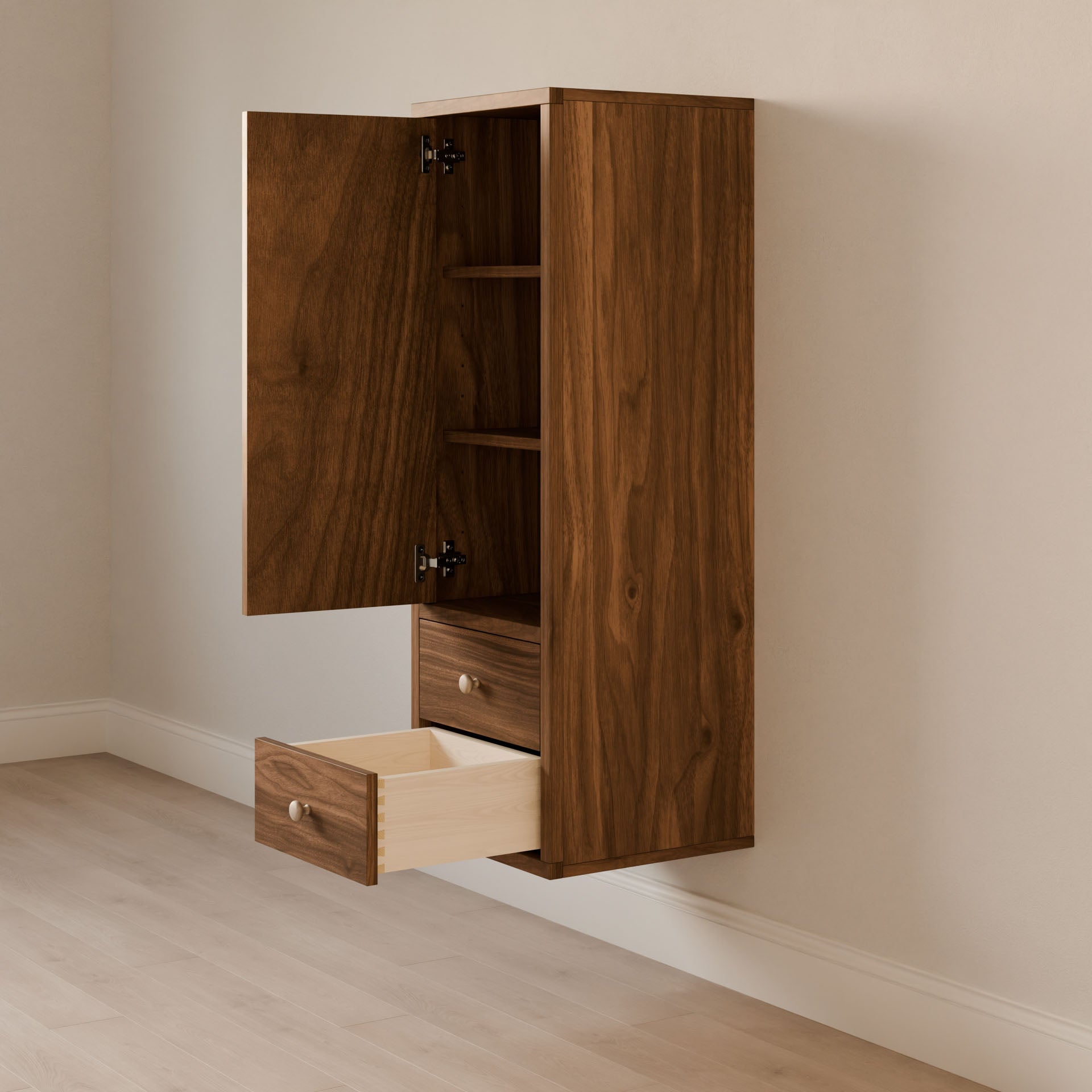 The Double Drawer Linen Cabinet in Walnut by Krovel Furniture Co. is a sustainably crafted, wall-mounted unit featuring a door with two shelves and an open drawer, perfectly suited for rooms with light wood floors and cream-colored walls, thanks to its customizable sizes.