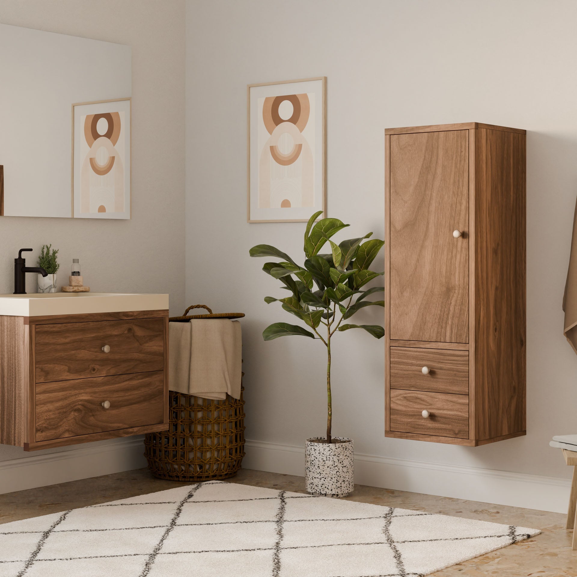 A minimalist bathroom showcases wooden cabinets, a white countertop with soap dispenser, and a potted plant. A Double Drawer Linen Cabinet in Walnut by Krovel Furniture Co. complements geometric art on the walls, with a wicker basket and beige rug anchoring the sustainable, neutral-toned space.