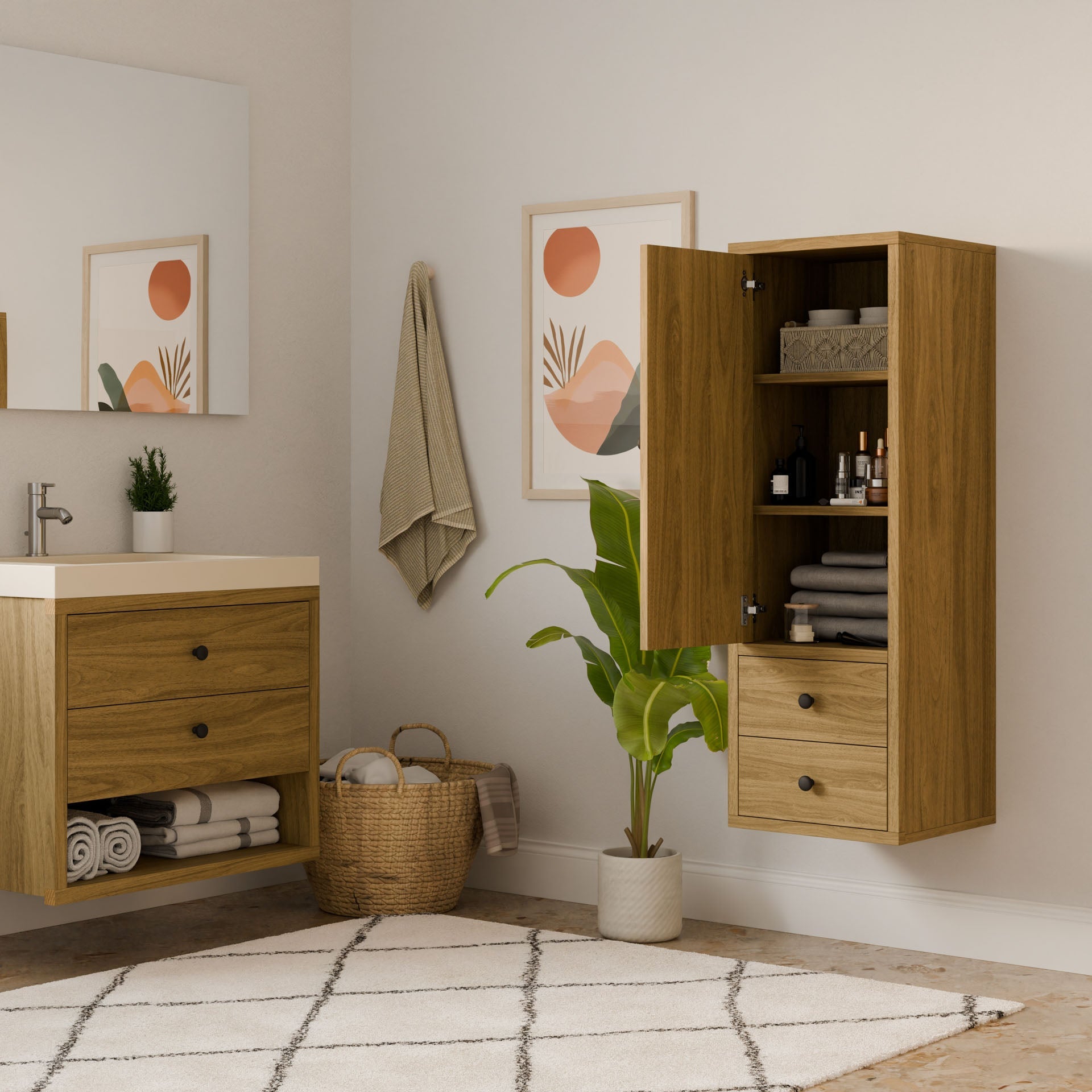 A modern bathroom features the Krovel Furniture Co. Maine Made Double Drawer Linen Cabinet, a wall-mounted vanity, a matching open wall cabinet with toiletries, plus a plant, basket, striped rug, towel, and abstract art.
