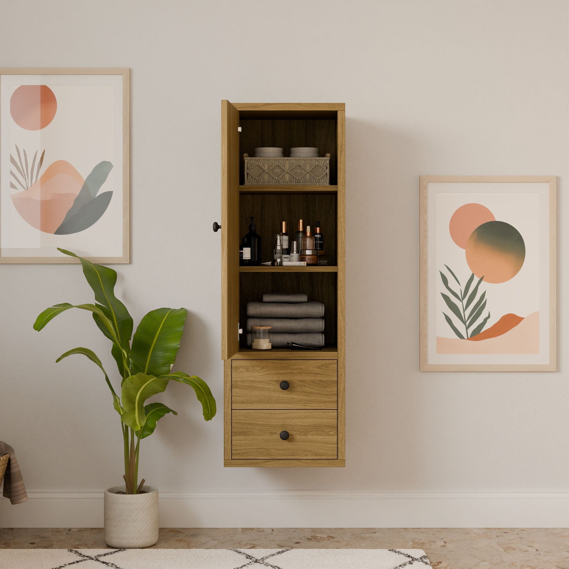 The wall-mounted Double Drawer Linen Cabinet in White Oak by Krovel Furniture Co. reveals towels and toiletries inside. Framed abstract geometric art adorns both sides, while a potted plant complements this example of sustainable construction on the floor below. Custom sizes are available.