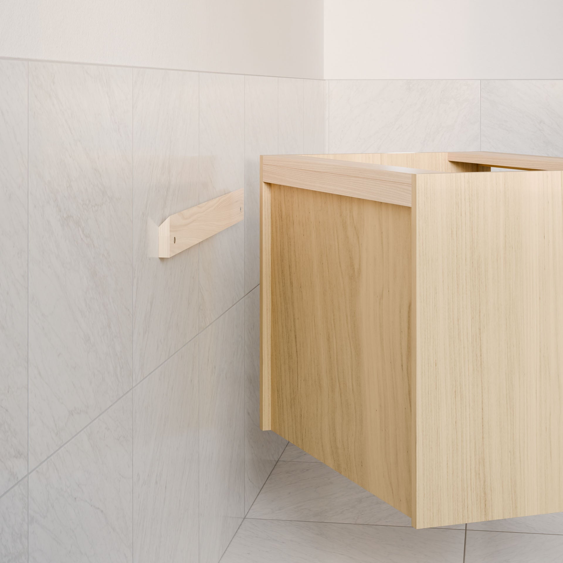 The Maine Made Double Drawer, Open Shelf Vanity by Krovel Furniture Co. is being installed on a white marble tiled wall, with a support bracket visible to the left.