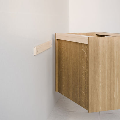 The Maine Made Double Drawer, Open Shelf Vanity by Krovel Furniture Co. features a light wood finish and modern lines. Mounted floating on a white wall with a rail, its sleek design brings contemporary style to any space.