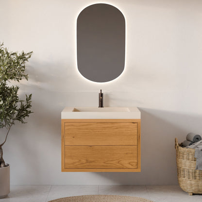The Double Drawer Vanity in Cherry by Krovel Furniture Co. features a modern floating design with a white sink, black faucet, oval backlit mirror, potted plant on the left, wicker basket with towels on the right. Custom sizes available.